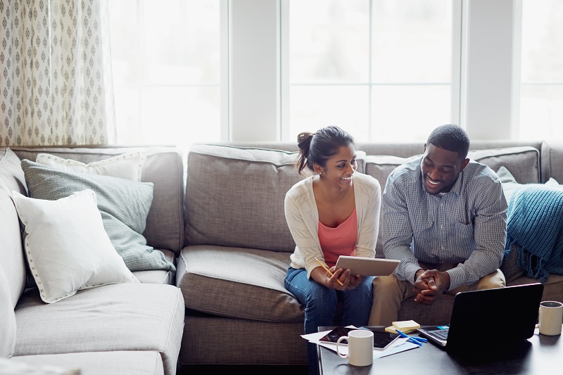 couple sitting on a couch going over finances