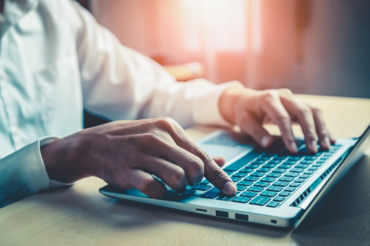 hands typing on a laptop