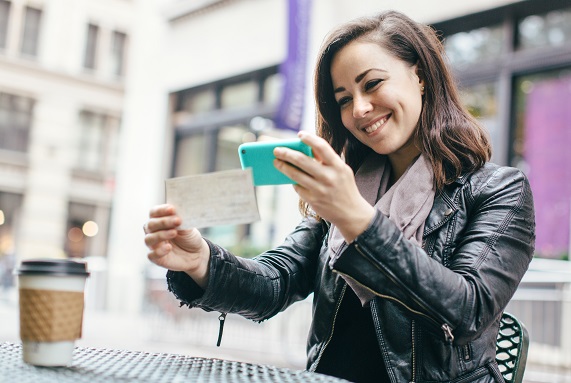 girl submitting a check for mobile deposit