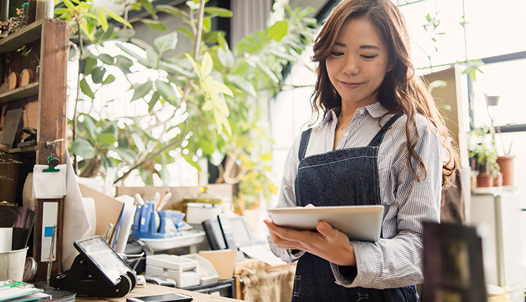 AAPI woman working on an iPad