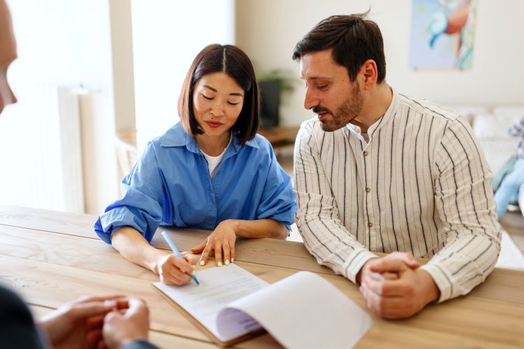 couple sitting at a table signing a contract